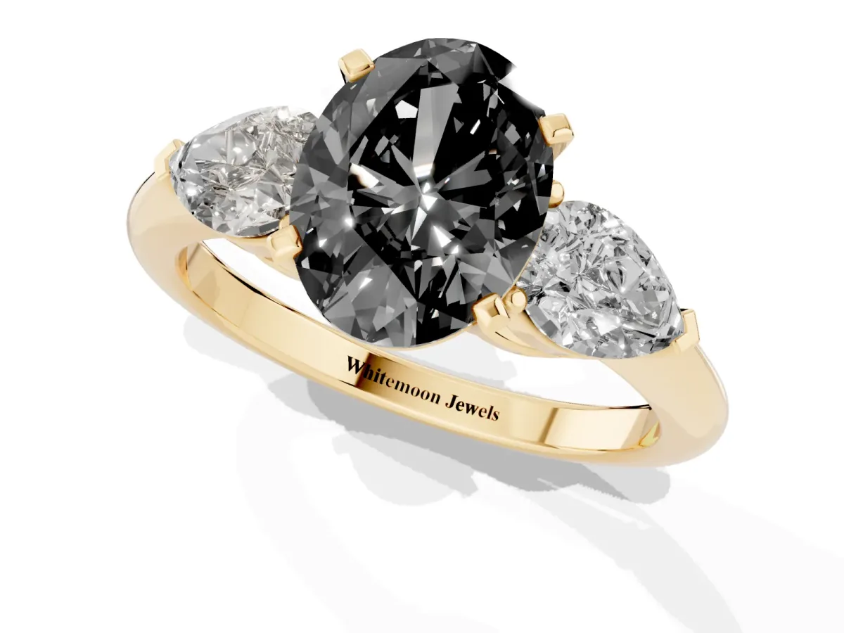 Fancy Black Three-Stone Oval Cut Diamond Ring with Pear Side Stones and Four-Prong Setting Yellow gold