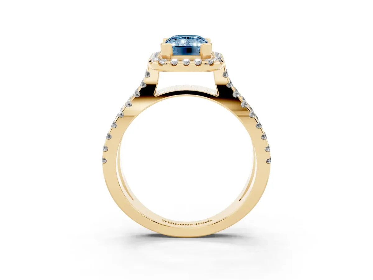Fancy Blue Emerald Cut Diamond Halo Ring with Split Shank Pavé Band and Prong Setting Yellow gold
