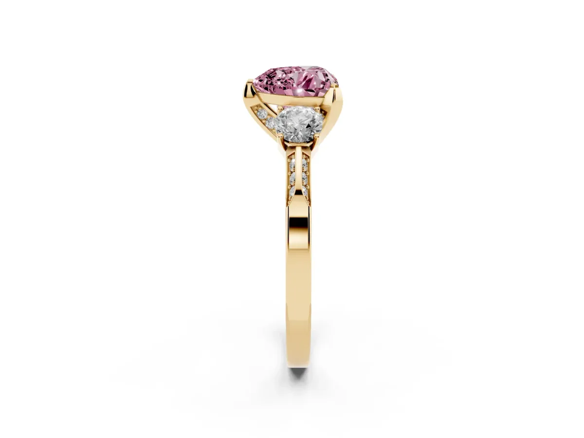 Fancy Pink Heart Cut Brilliant Three-Stone Diamond Ring with Pavé Band and Four-Prong Setting Yellow gold