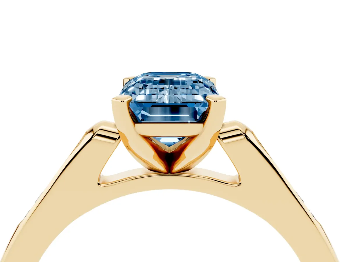 Fancy Blue Emerald Cut Diamond Solitaire Ring with Channel Set Round Band and Prong Setting Yellow gold