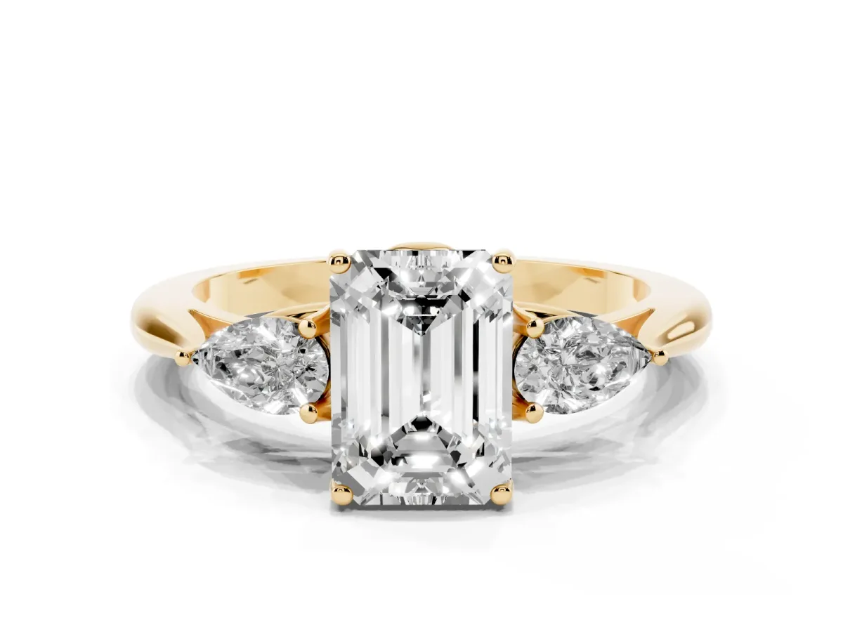 Three-Stone Emerald Cut Diamond Ring with Pear Side Stones in Four-Prong Setting Yellow gold