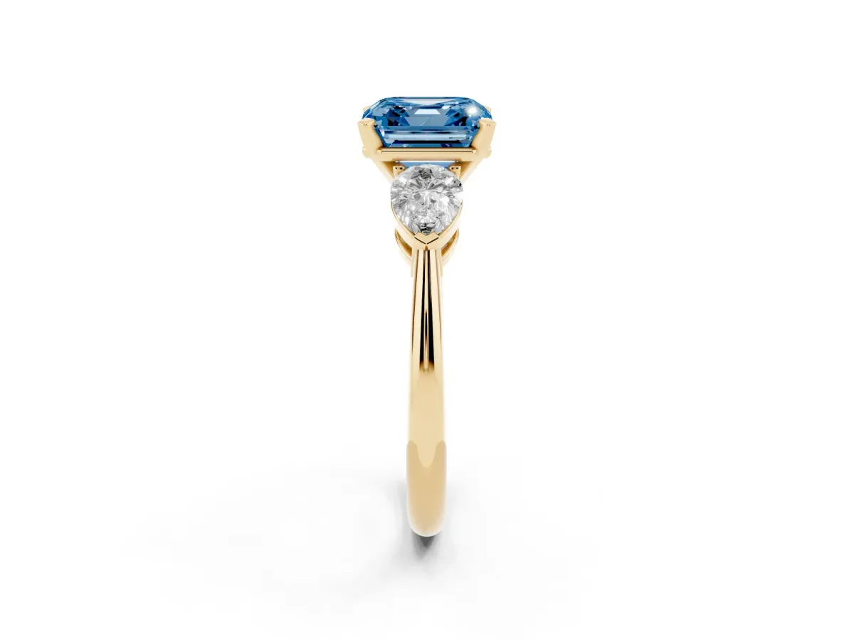 Fancy Blue Three-Stone Asscher Cut Diamond Ring with Pear Side Stones and Four-Prong Setting Yellow gold