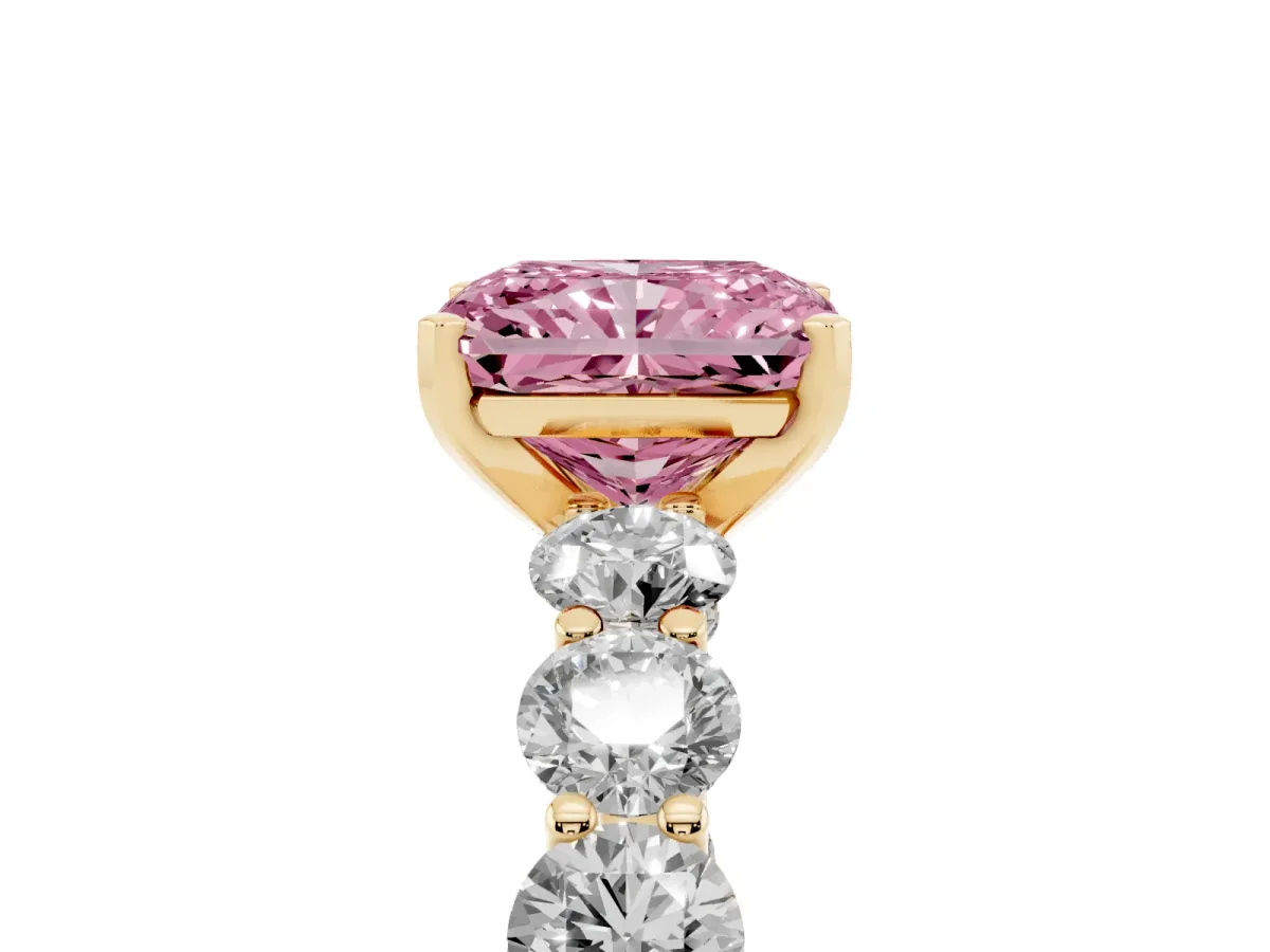 Fancy Pink Radiant Cut Diamond Prong Setting with Side Stones on a Pave Band Yellow gold