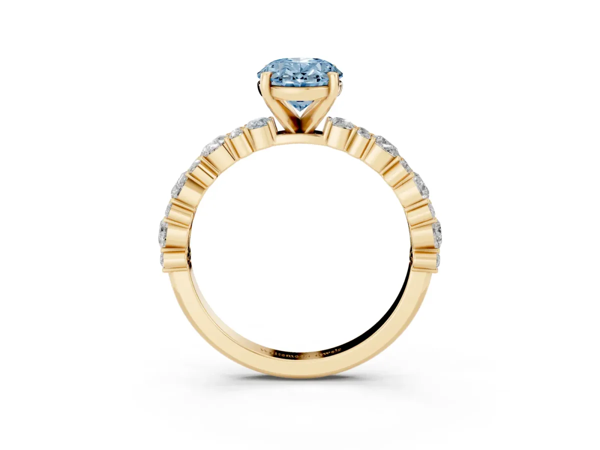 Fancy Blue Oval Cut Diamond Side Stone Solitaire Ring with Round and Four-Prong Setting Yellow gold