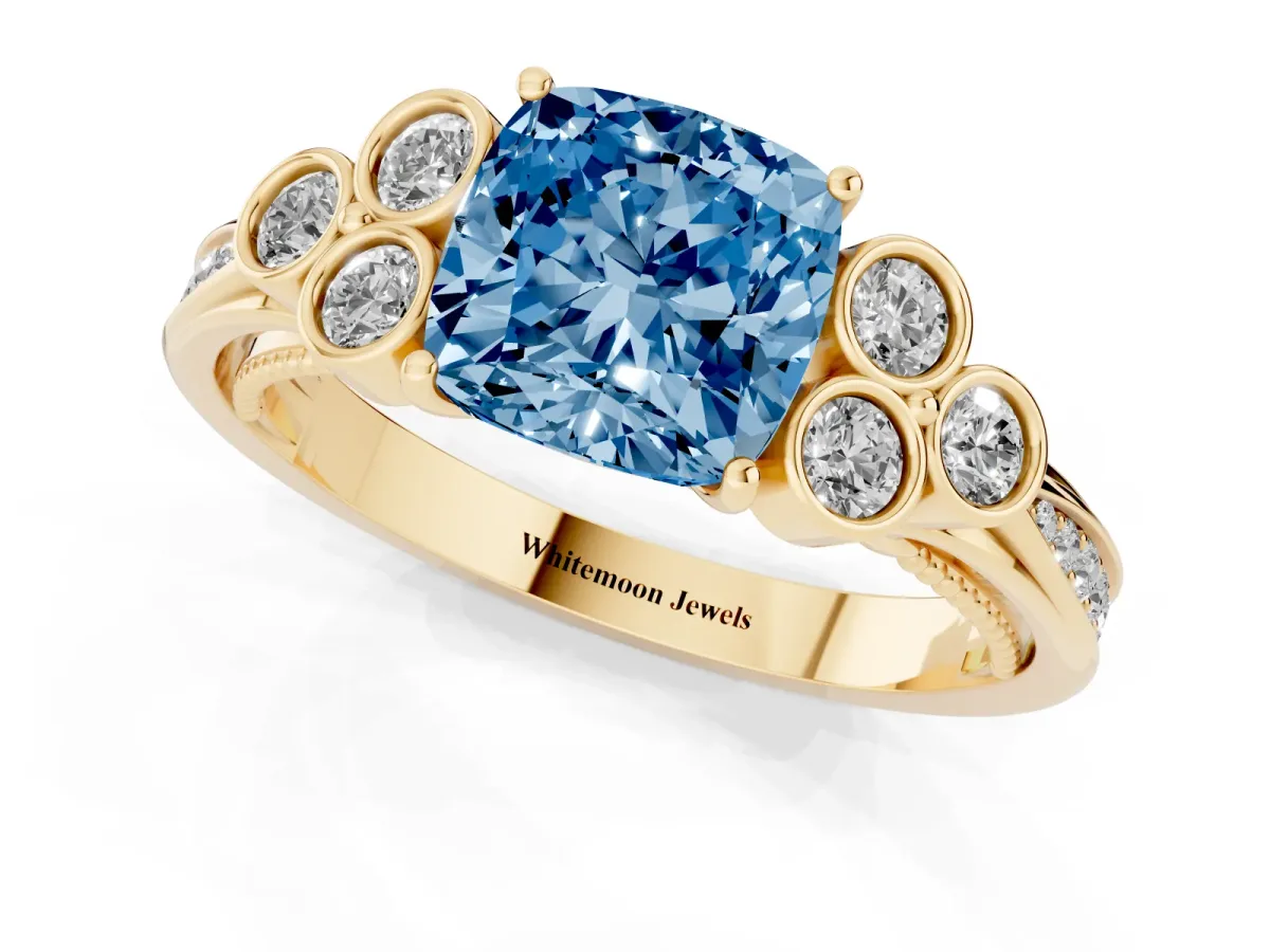 Fancy Blue Cushion Cut Cut Diamond Engagement Ring with Bezel Set Round Side Stones and Prong Setting Yellow gold