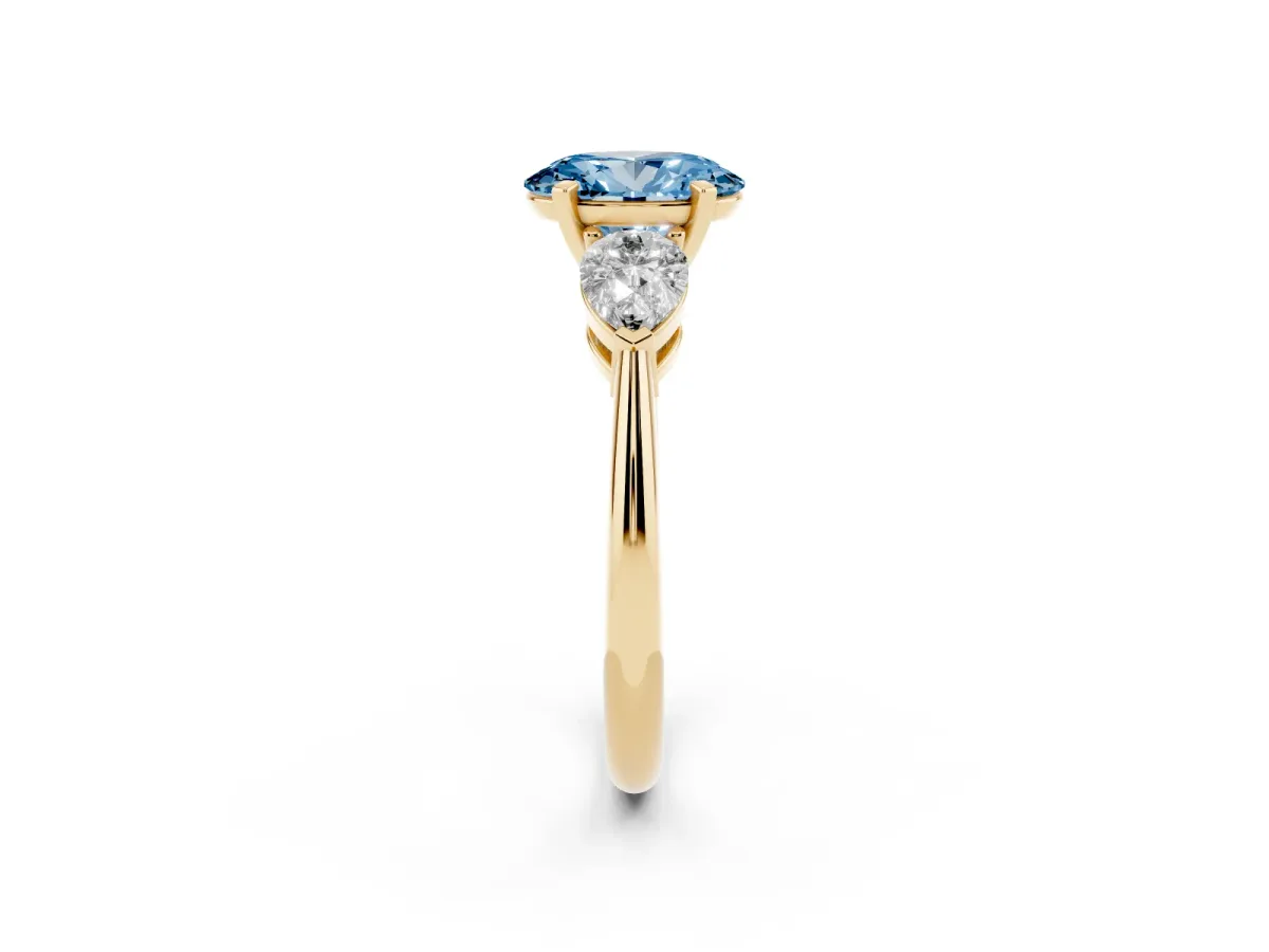 Fancy Blue Three-Stone Oval Cut Diamond Ring with Pear Side Stones and Four-Prong Setting Yellow gold