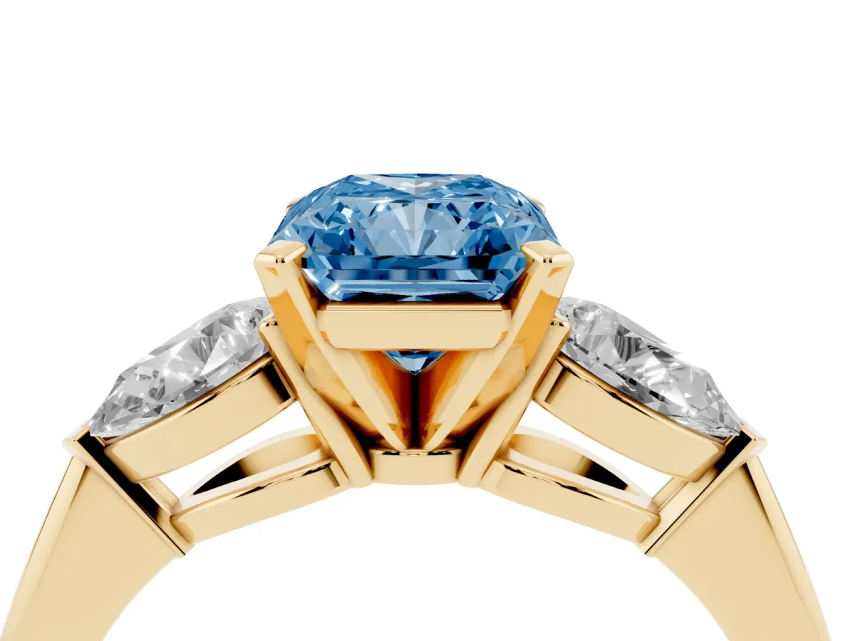 Fancy Blue Three-Stone Radiant Cut Diamond Ring with Pear Side Stones and Four-Prong Setting Yellow gold
