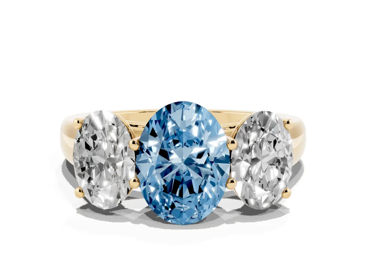 Fancy Blue Oval Cut Three-Stone Diamond Ring with Prong Setting on a Classic Band Yellow gold