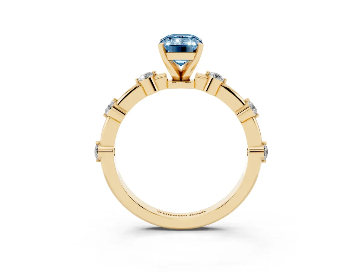 Fancy Blue Emerald Cut Solitaire Diamond Ring with Bezel Set Side Stones and Prong Setting Yellow gold