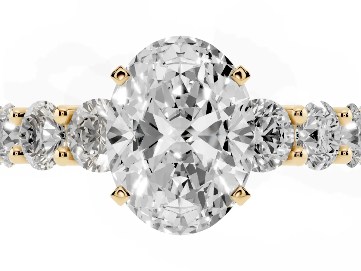 Oval Cut Diamond Prong Setting with Side Stones on a Pave Band Yellow gold