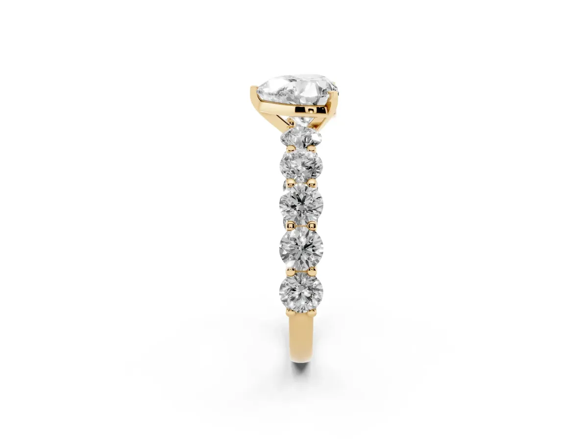 Heart Cut Diamond Prong Setting with Side Stones on a Pave Band Yellow gold