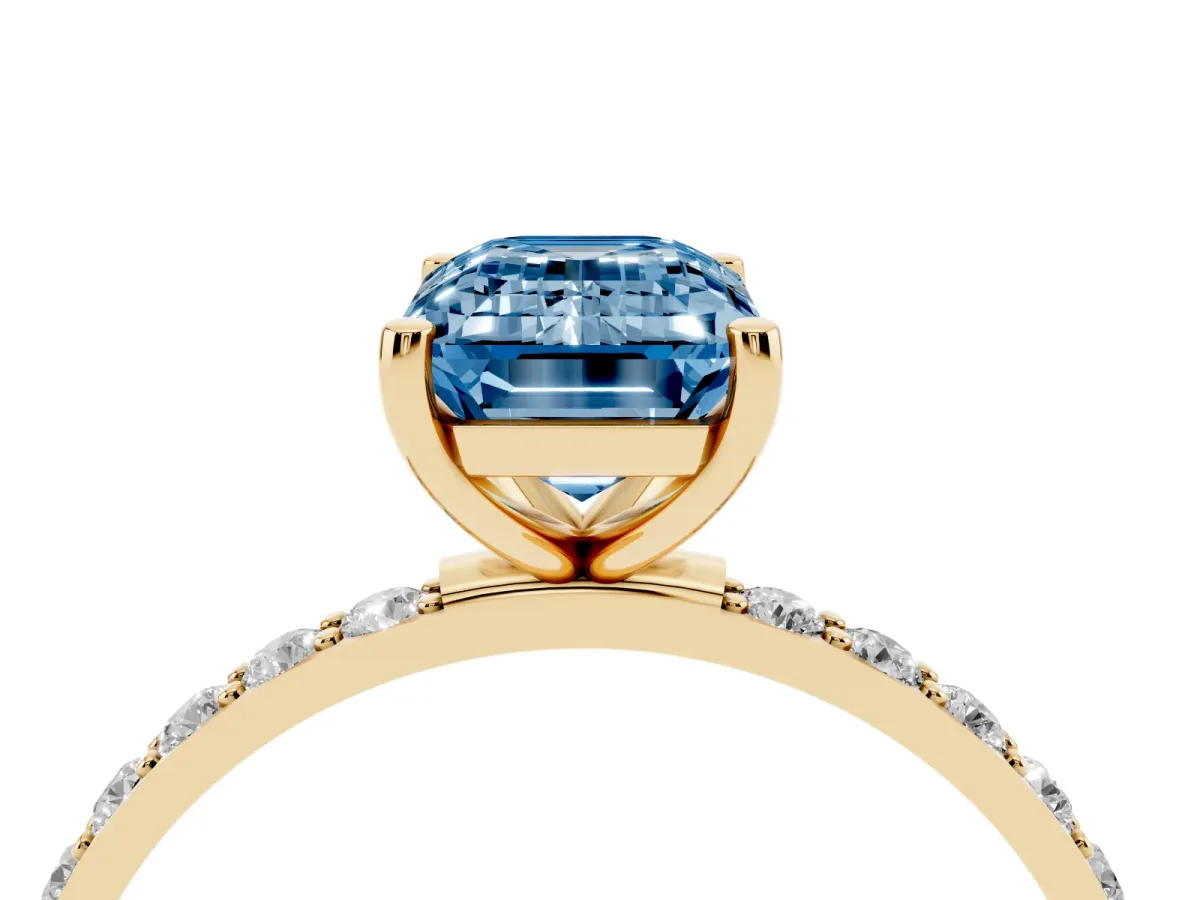 Fancy Blue Emerald Cut Diamond Solitaire Ring with Round Pavé Shoulders and Prong Setting Yellow gold
