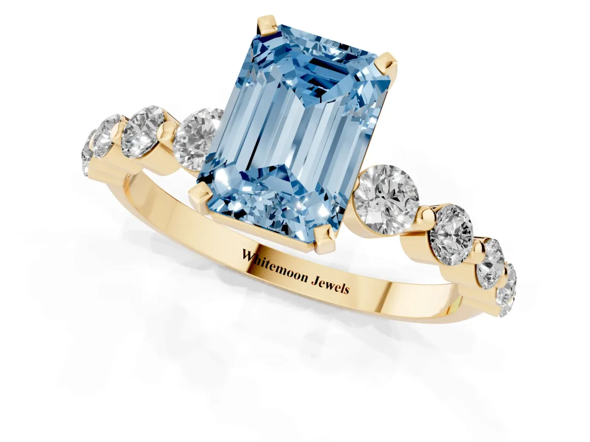 Fancy Blue Emerald Cut Solitaire Diamond Ring with Pave Band and Four-Prong Setting Yellow gold