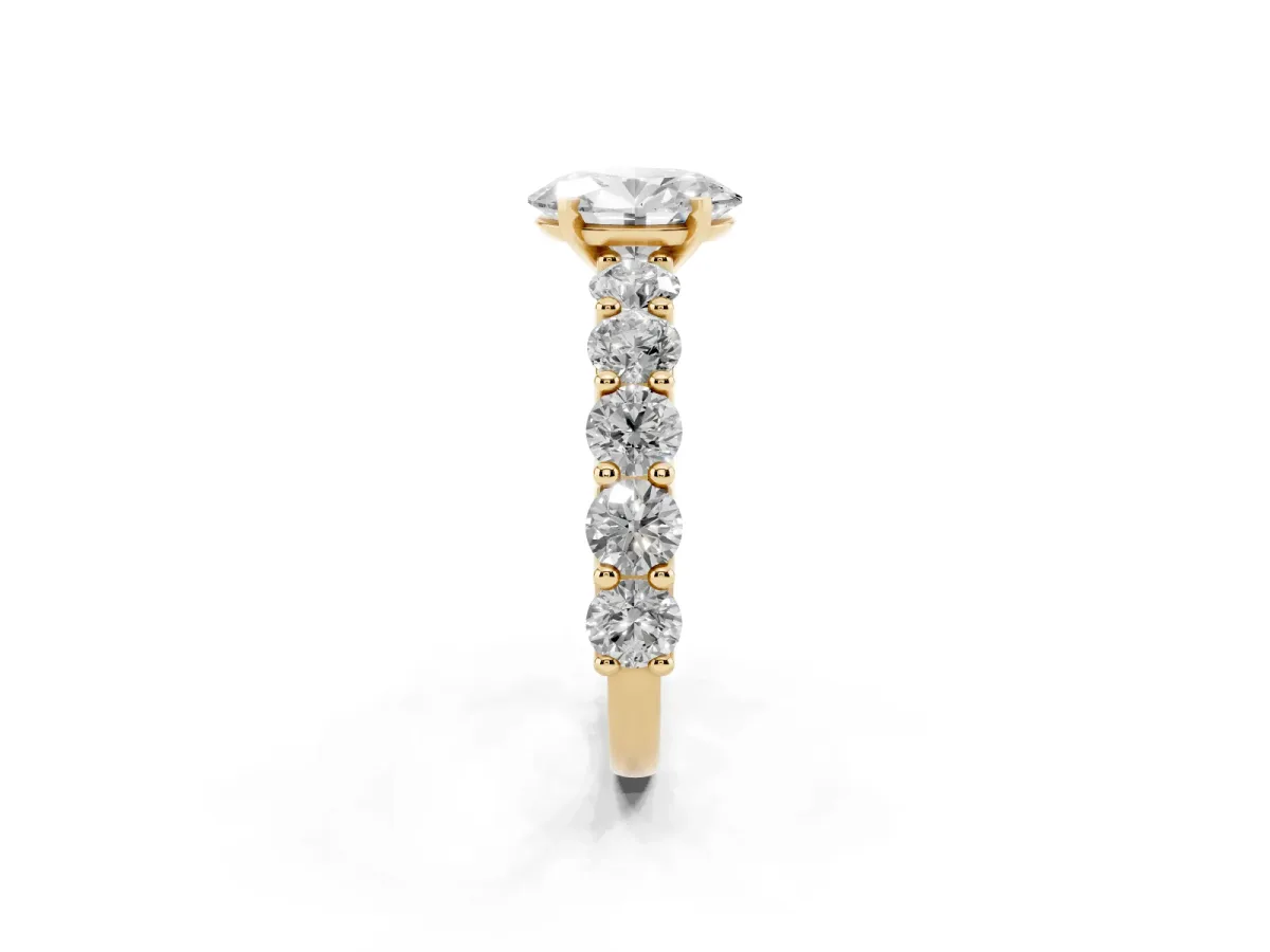 Oval Cut Diamond Prong Setting with Side Stones on a Pave Band Yellow gold