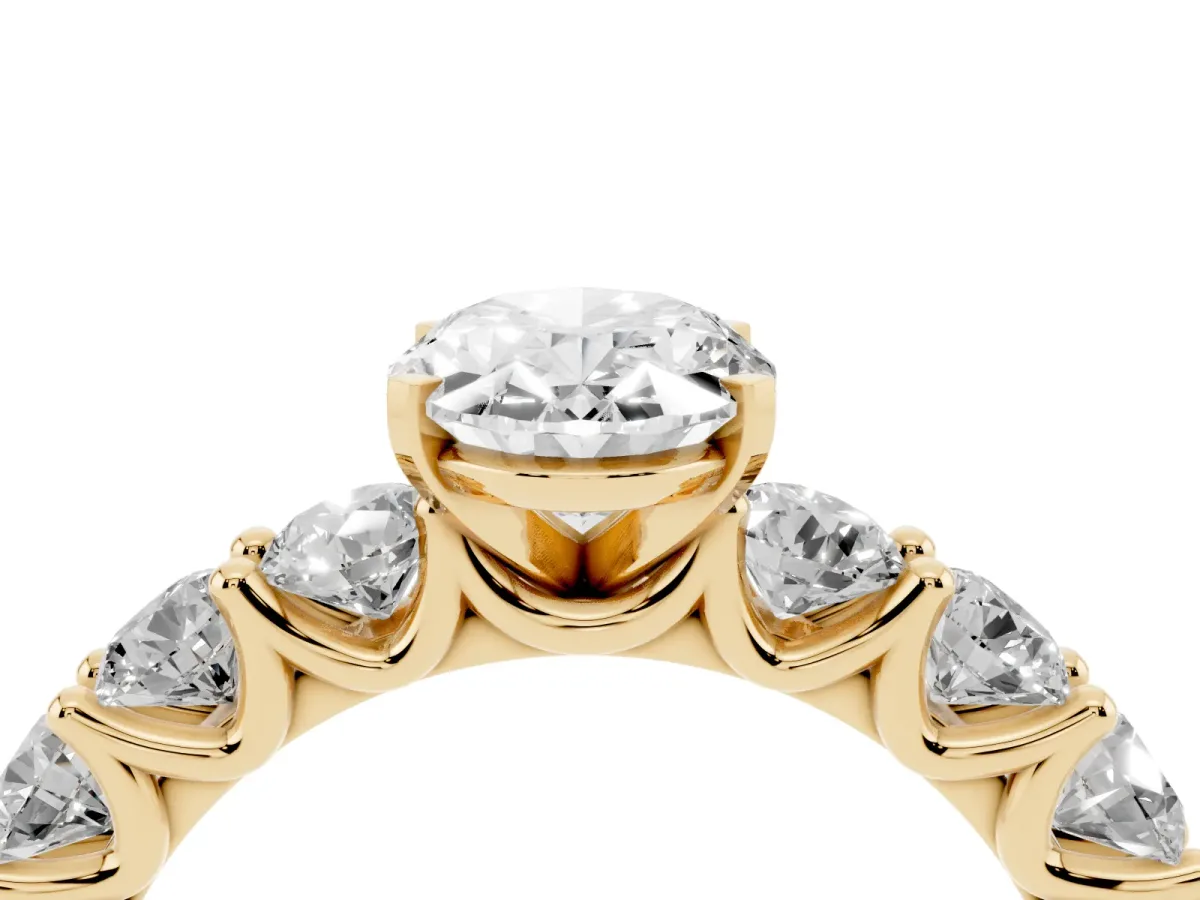 Oval Cut Diamond Prong Setting with Side Stones on a Pave Band Yellow gold