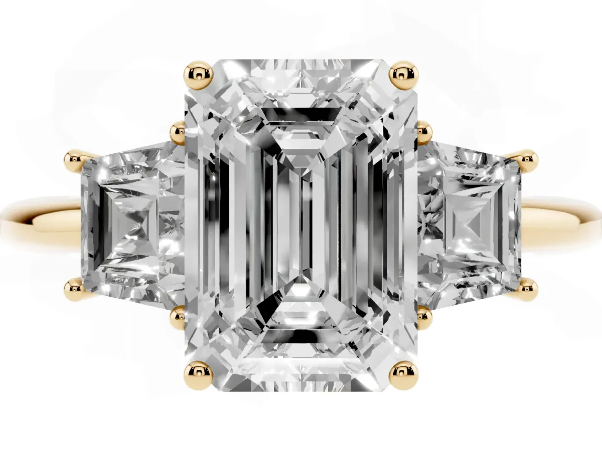 Emerald Cut Diamond Three-Stone Ring with Trapezoid Side Stones and Prong Setting Yellow gold