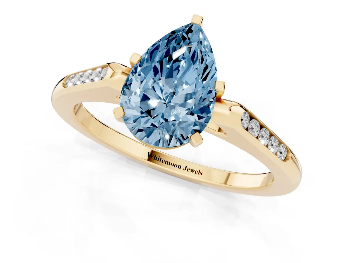 Fancy Blue Pear Cut Diamond Solitaire Ring with Channel Set Round Band and Prong Setting Yellow gold