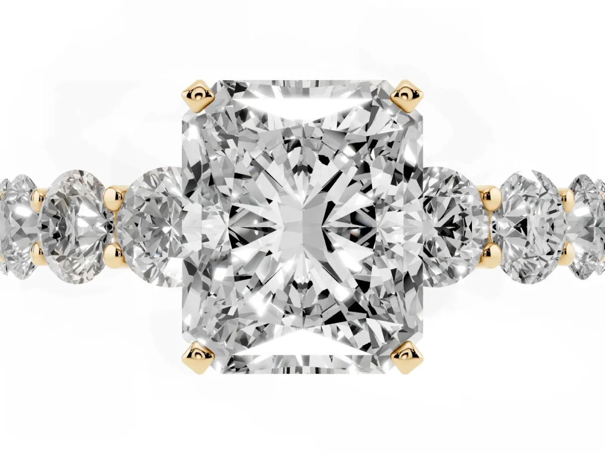 Radiant Cut Diamond Prong Setting with Side Stones on a Pave Band Yellow gold