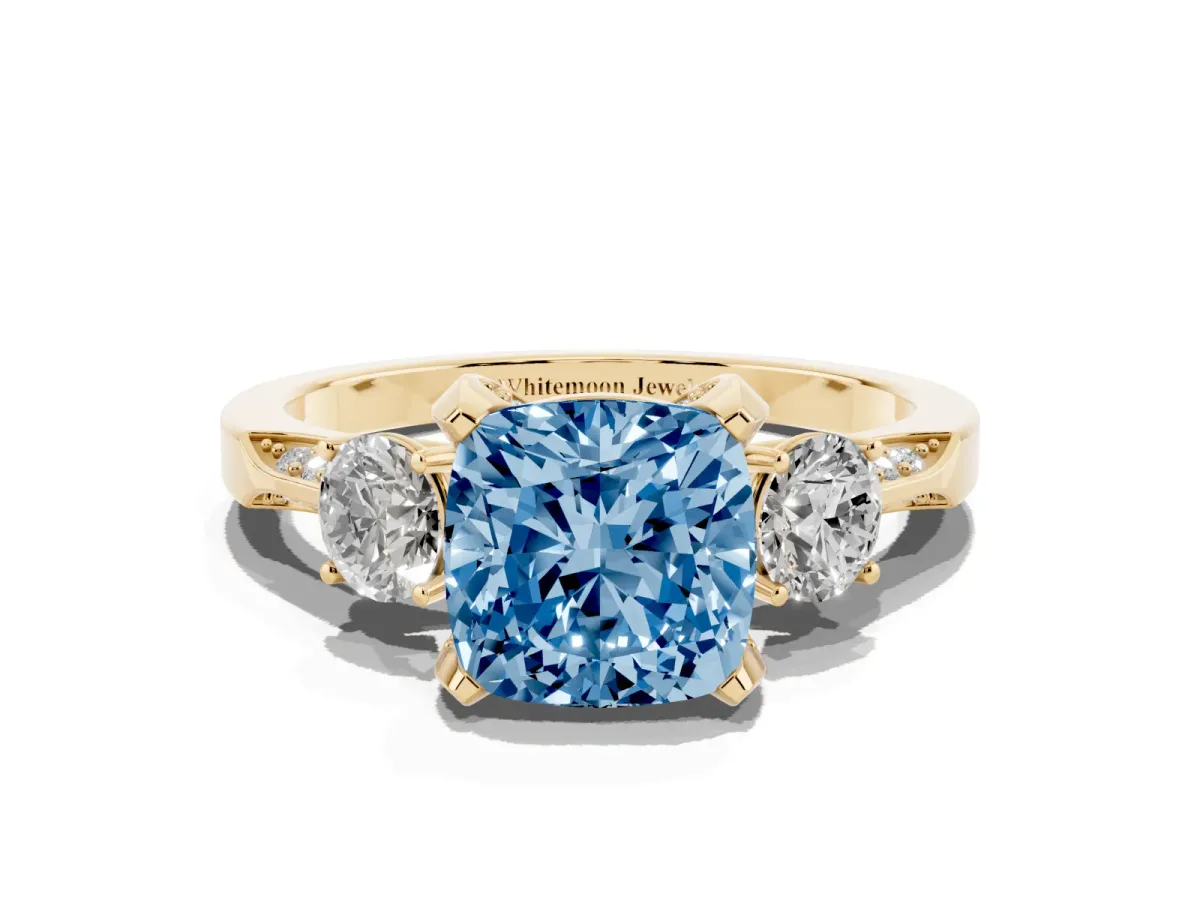Fancy Blue Cushion Cut Brilliant Three-Stone Diamond Ring with Pavé Band and Four-Prong Setting Yellow gold