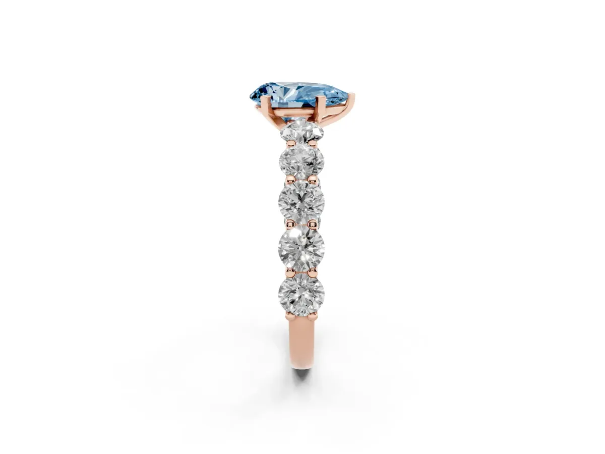 Fancy Blue Pear Cut Diamond Prong Setting with Side Stones on a Pave Band Rose gold