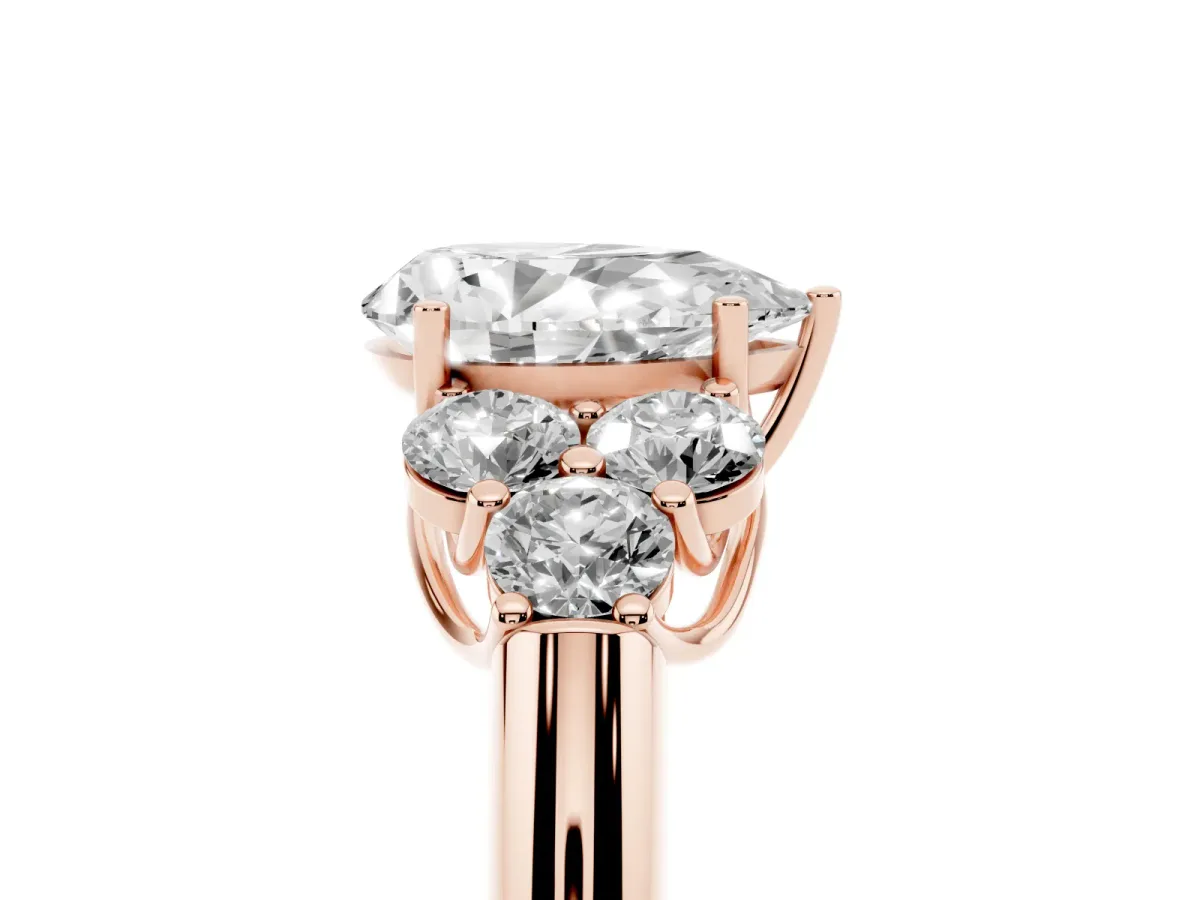 Pear Cut Cut Diamond Cluster Ring with Round Accent Stones and Prong Setting on a Classic Band Rose gold