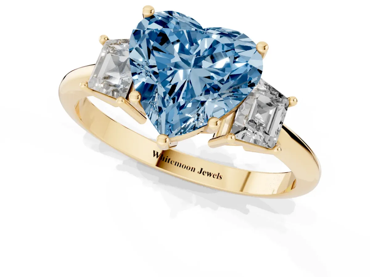 Fancy Blue Heart Cut Diamond Three-Stone Ring with Trapezoid Side Stones and Prong Setting Yellow gold