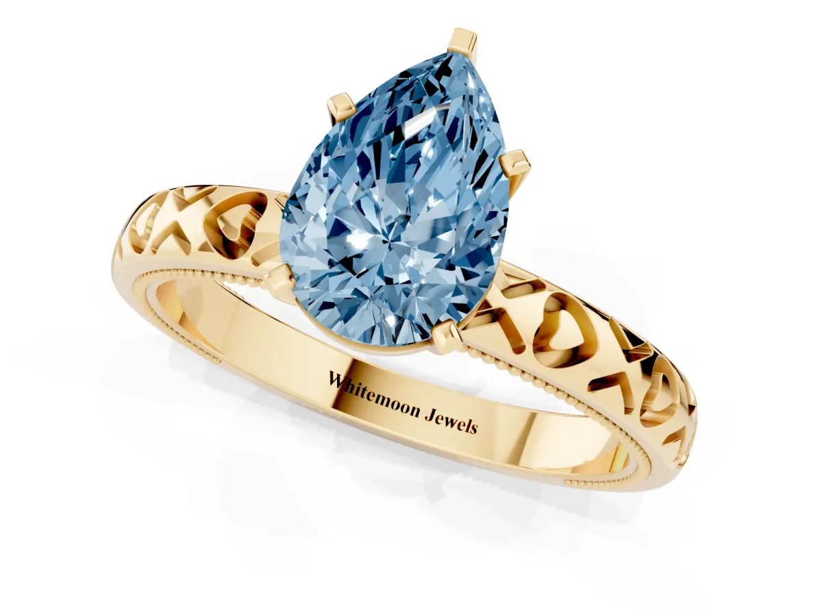 Fancy Blue Pear Cut Solitaire Diamond Engagement Ring with XO Engraved Band and Four-Prong Setting Yellow gold