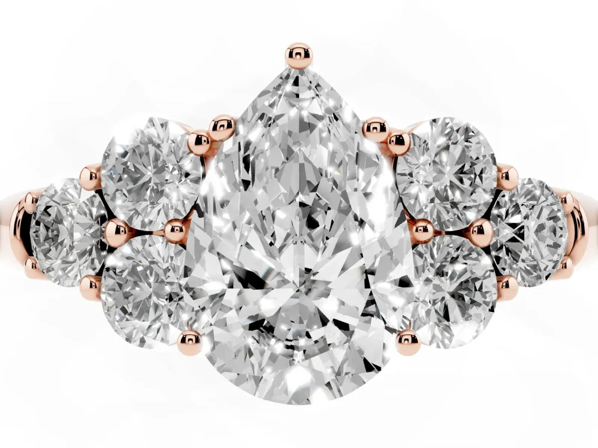 Pear Cut Cut Diamond Cluster Ring with Round Accent Stones and Prong Setting on a Classic Band Rose gold