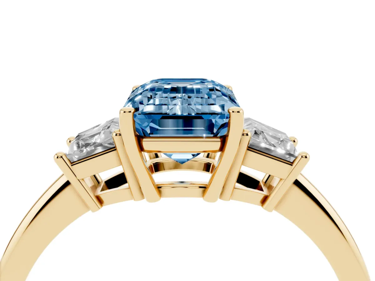 Fancy Blue Emerald Cut Diamond Three-Stone Ring with Trapezoid Side Stones and Prong Setting Yellow gold