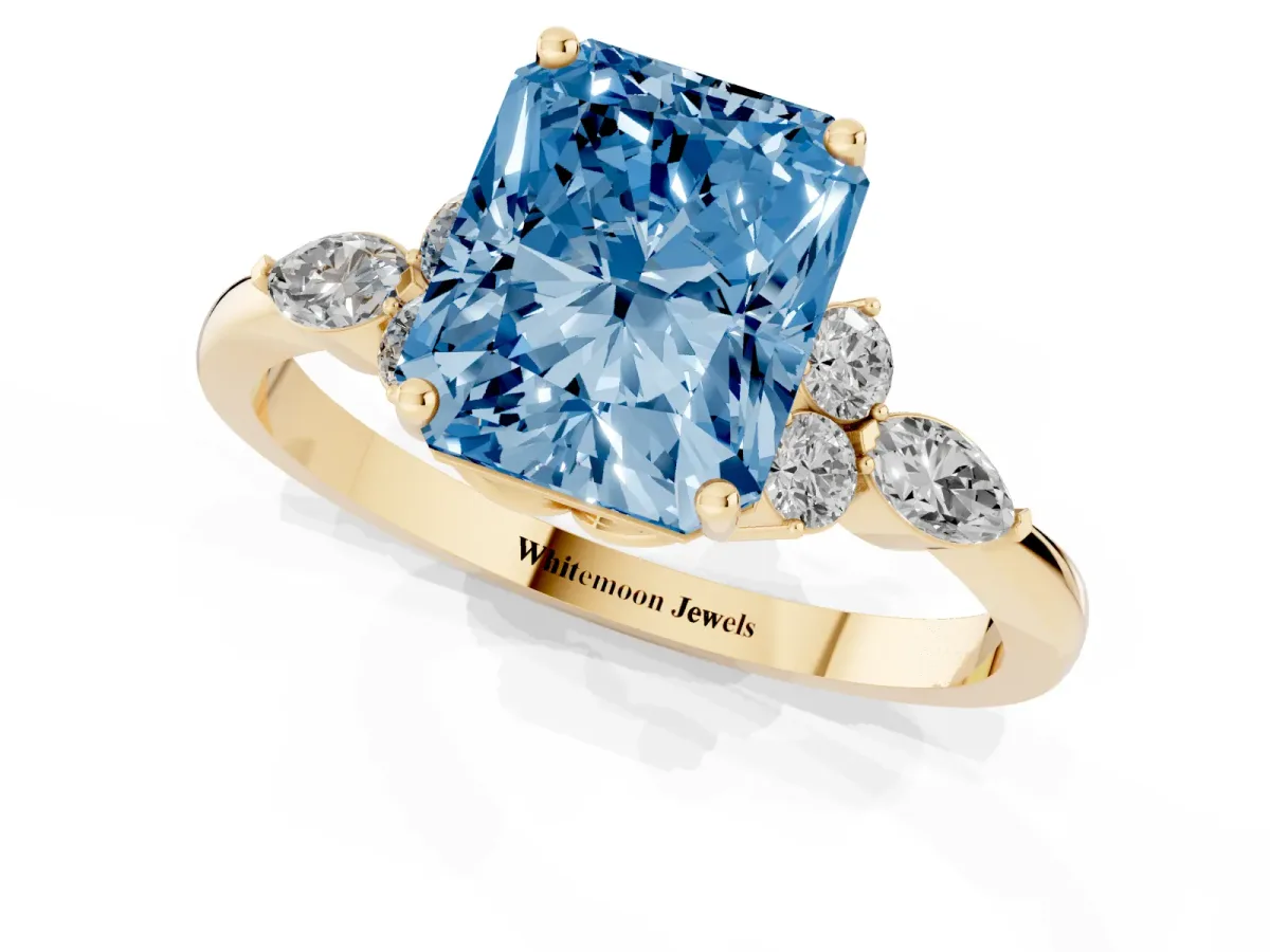 Fancy Blue Radiant Cut Brilliant Diamond Solitaire Ring with Pear Side Stones and Four-Prong Setting Yellow gold