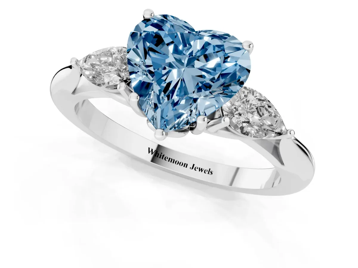 Fancy Blue Three-Stone Heart Cut Brilliant Diamond Solitaire Ring with Tapered Band and Four-Prong Setting White gold