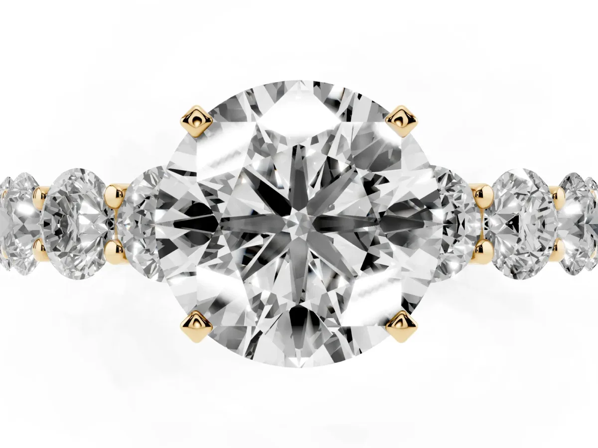 Round Cut Diamond Prong Setting with Side Stones on a Pave Band Yellow gold