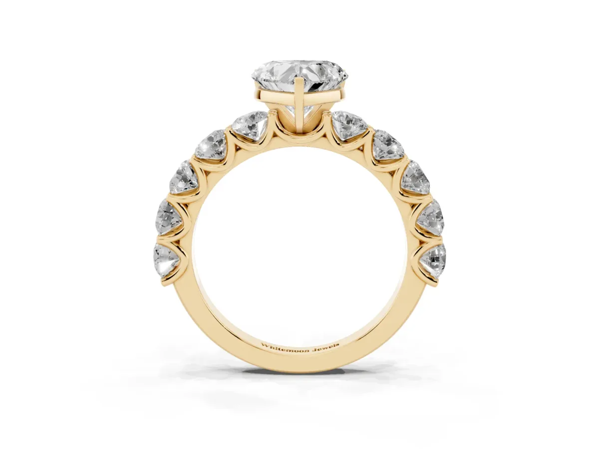 Heart Cut Diamond Prong Setting with Side Stones on a Pave Band Yellow gold