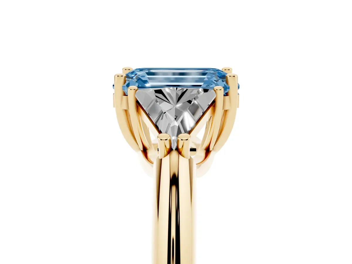 Fancy Blue Three-Stone Emerald Cut Diamond Engagement Ring with Trillion Side Stones and Prong Setting Yellow gold
