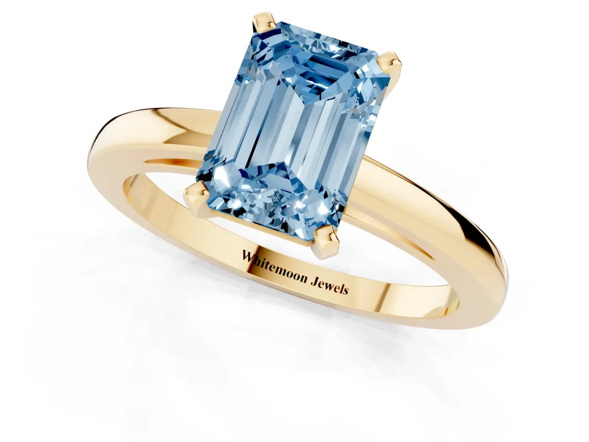 Fancy Blue Emerald Cut Solitaire Diamond Engagement Ring with Four-Prong Setting on a Classic Band Yellow gold