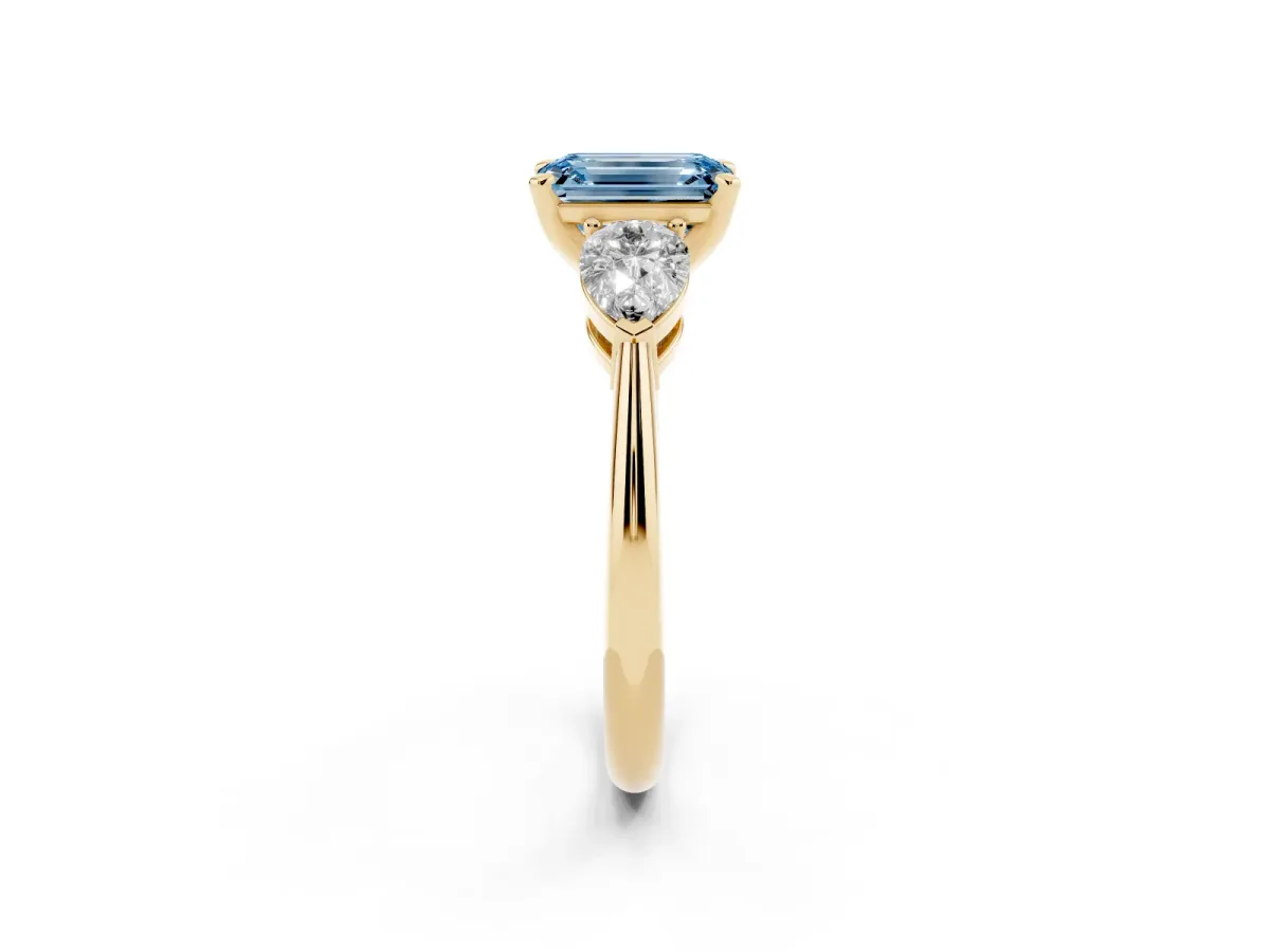 Fancy Blue Three-Stone Emerald Cut Diamond Ring with Pear Side Stones and Four-Prong Setting Yellow gold