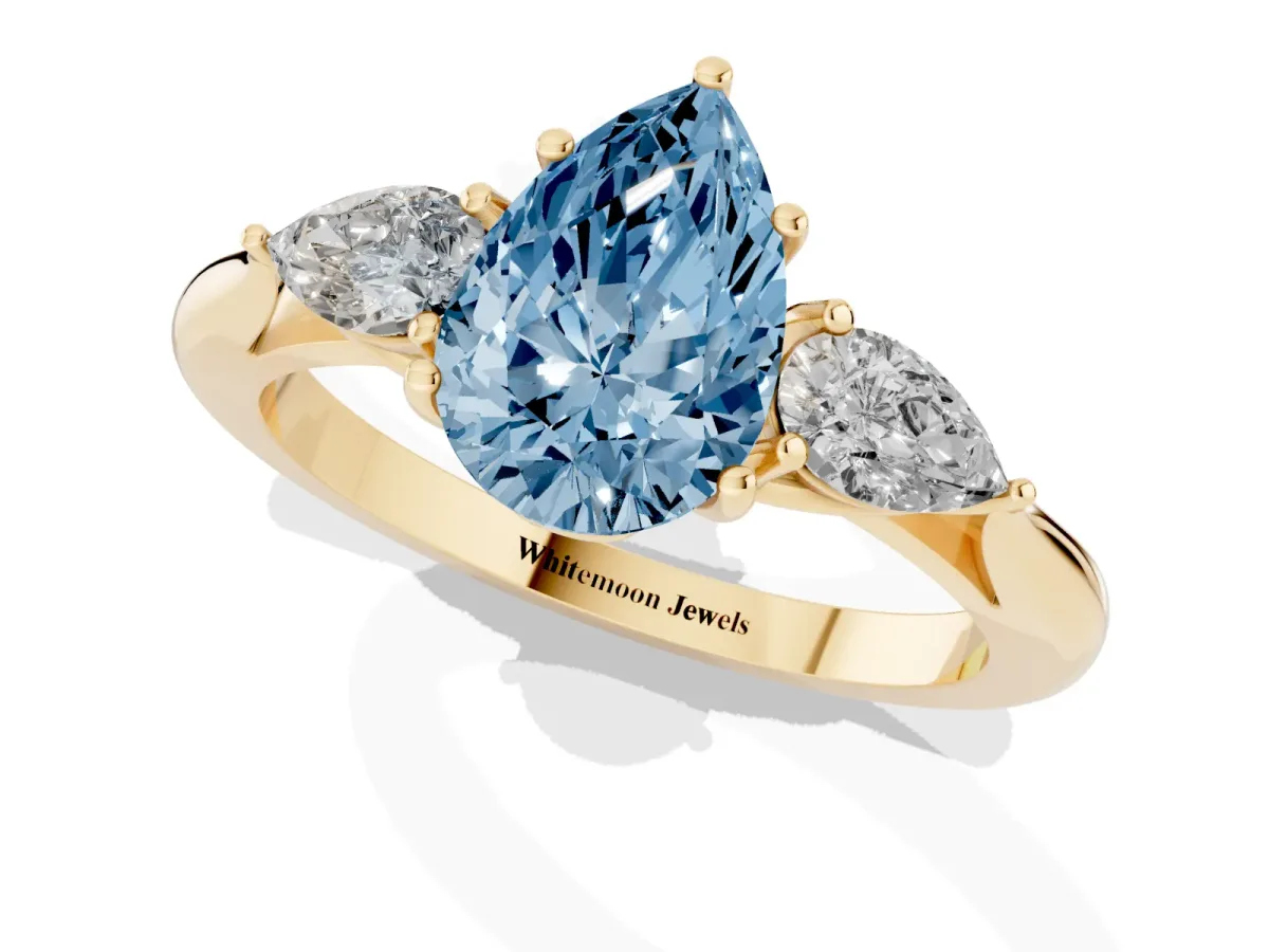 Fancy Blue Three-Stone Pear Cut Brilliant Diamond Solitaire Ring with Tapered Band and Four-Prong Setting Yellow gold
