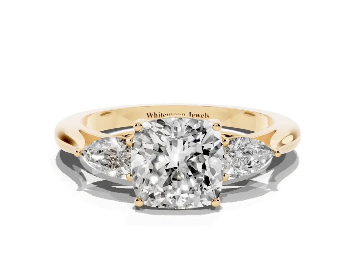 Three-Stone Cushion Cut Diamond Ring with Pear Side Stones in Four-Prong Setting Yellow gold