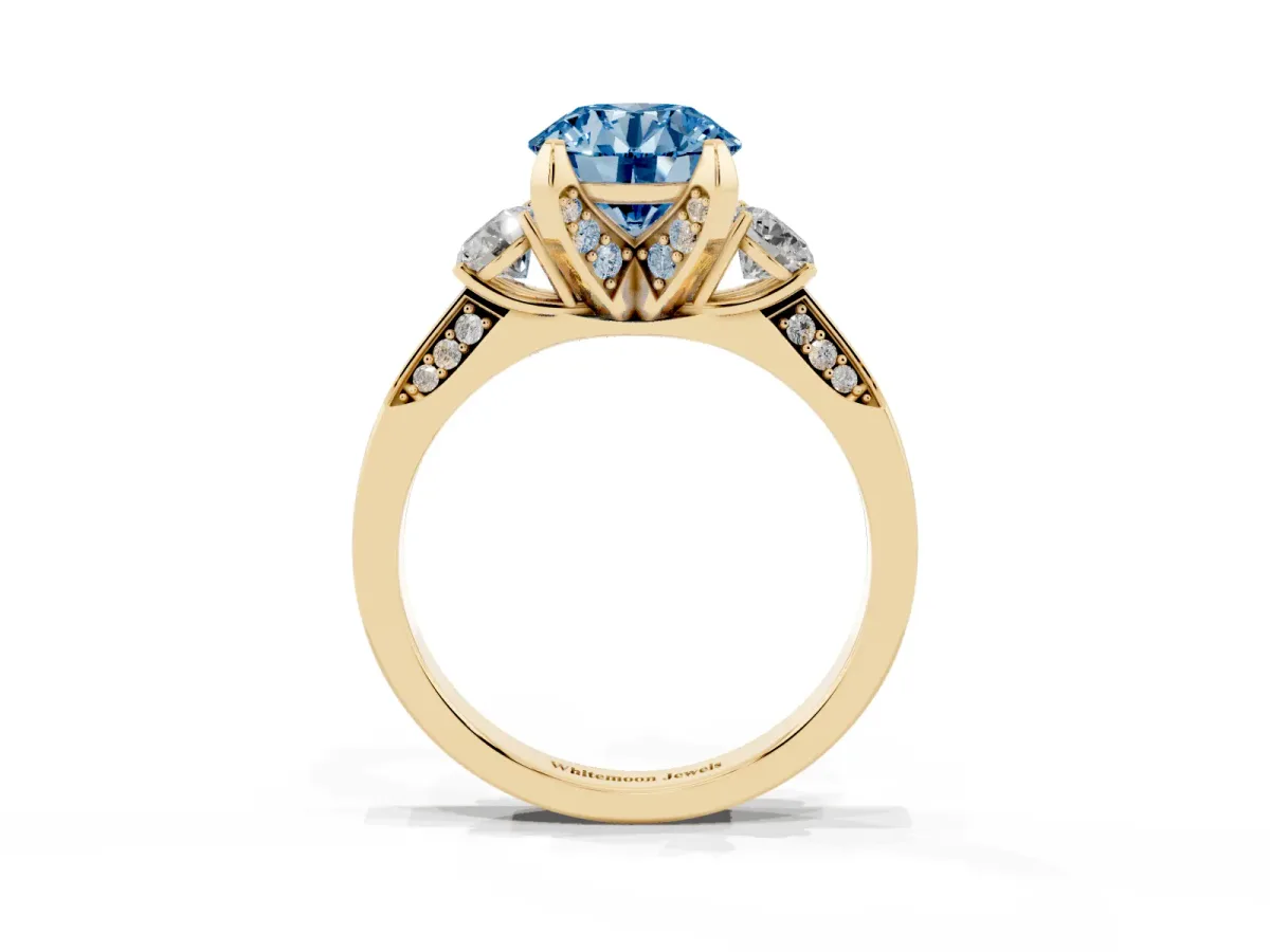 Fancy Blue Round Cut Brilliant Three-Stone Diamond Ring with Pavé Band and Four-Prong Setting Yellow gold