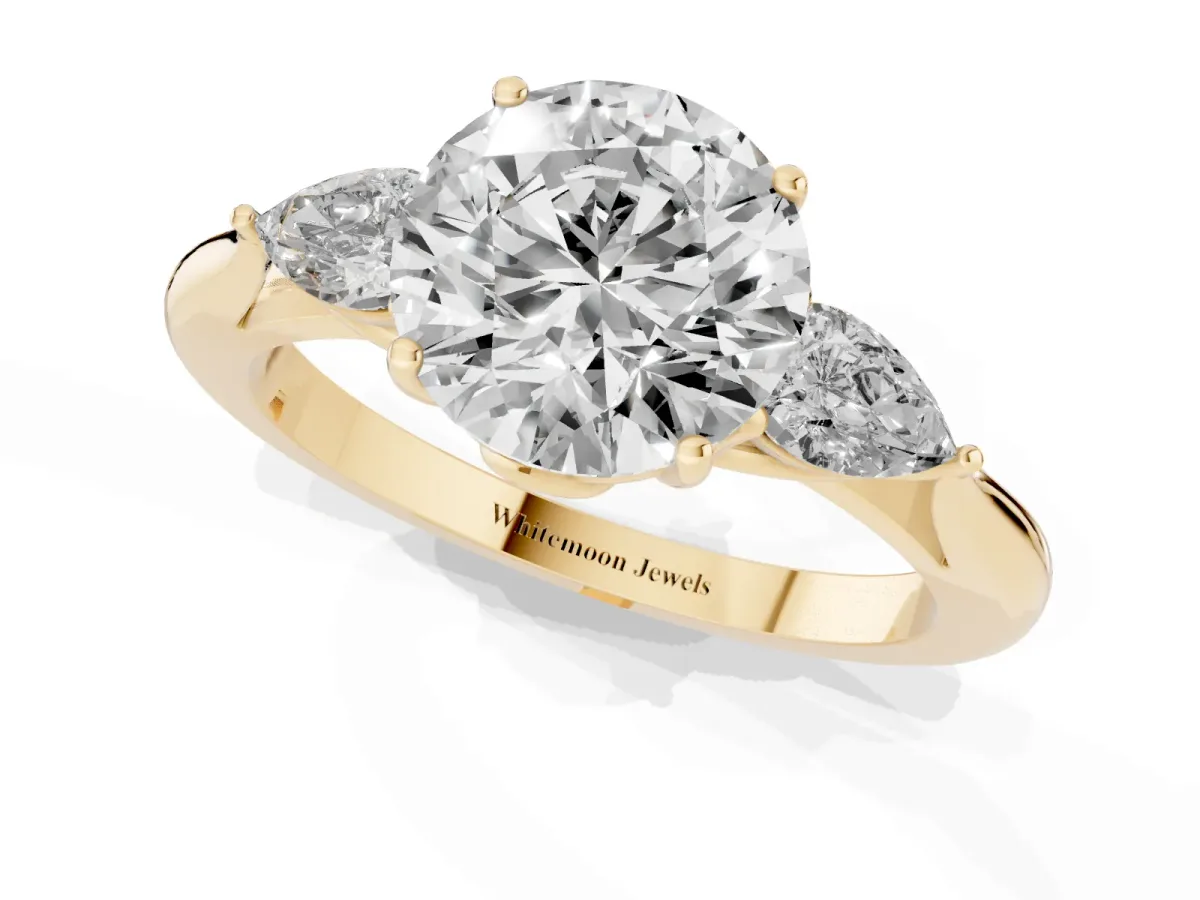 Three-Stone Round Cut Diamond Ring with Pear Side Stones in Four-Prong Setting Yellow gold