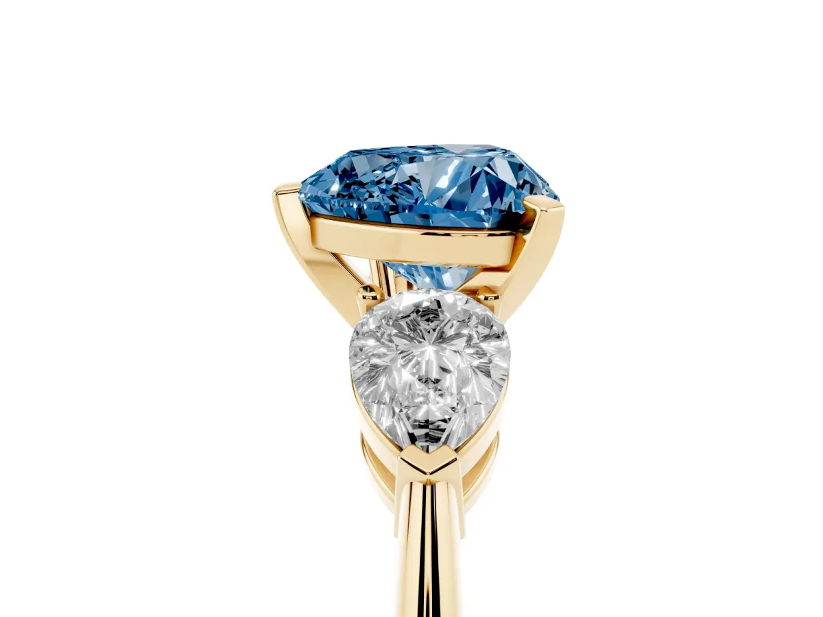 Fancy Blue Three-Stone Heart Cut Diamond Ring with Pear Side Stones and Four-Prong Setting Yellow gold