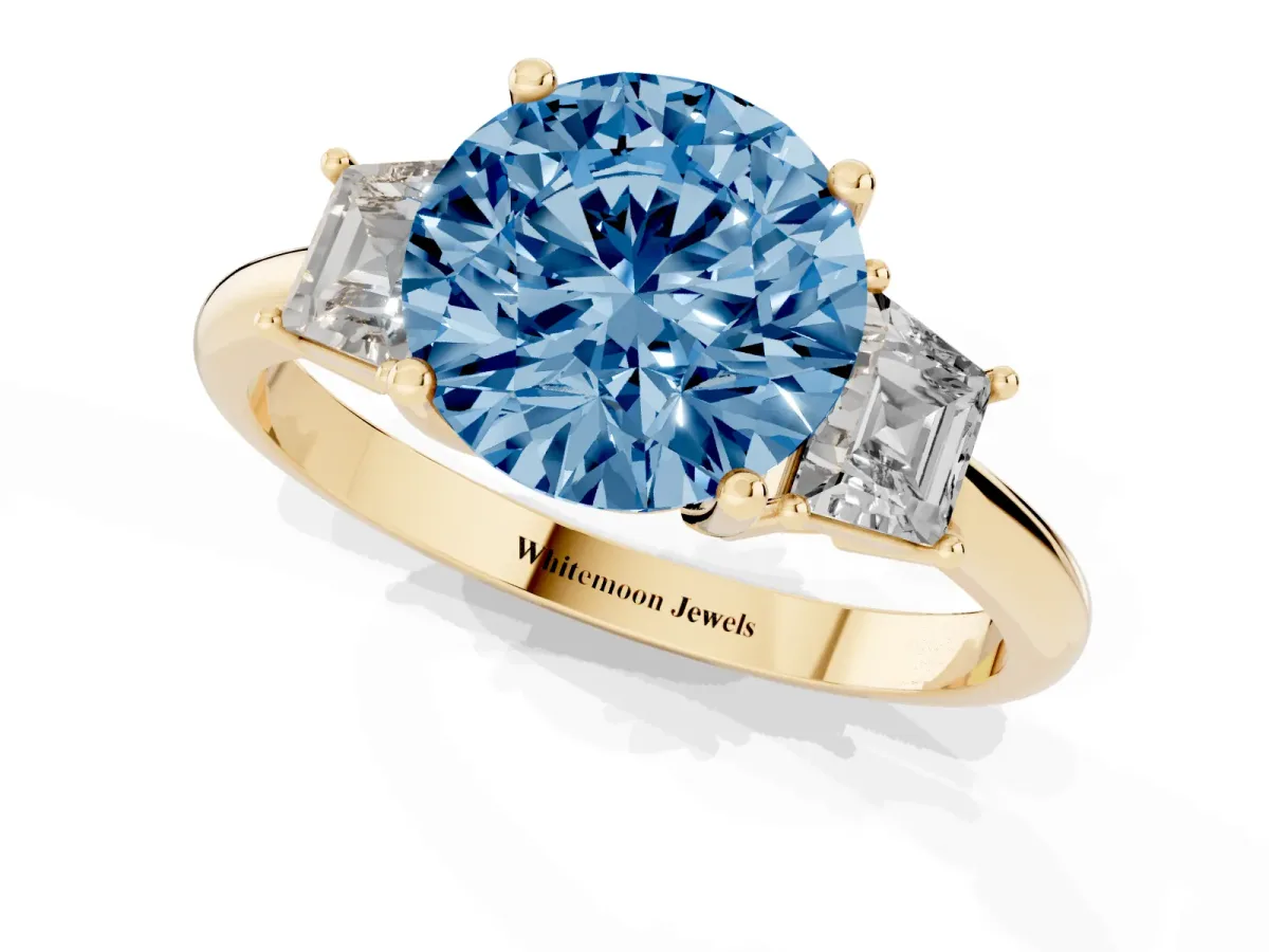 Fancy Blue Round Cut Diamond Three-Stone Ring with Trapezoid Side Stones and Prong Setting Yellow gold