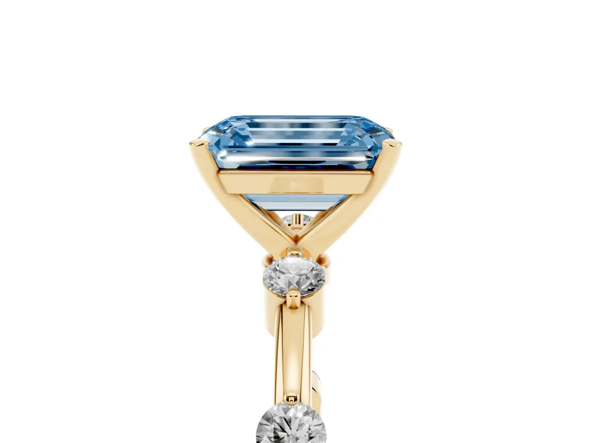 Fancy Blue Emerald Cut Solitaire Diamond Ring with Bezel Set Side Stones and Prong Setting Yellow gold
