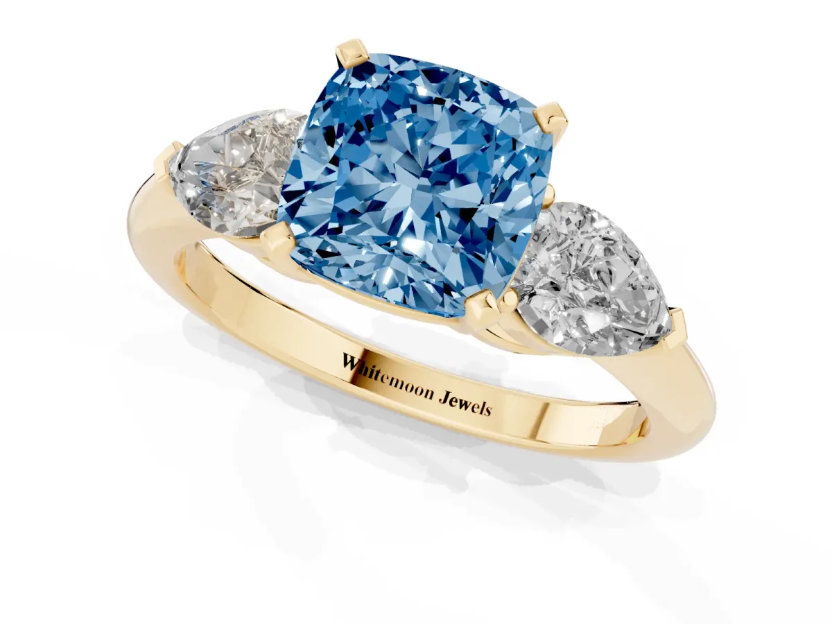 Fancy Blue Three-Stone Cushion Cut Diamond Ring with Pear Side Stones and Four-Prong Setting Yellow gold