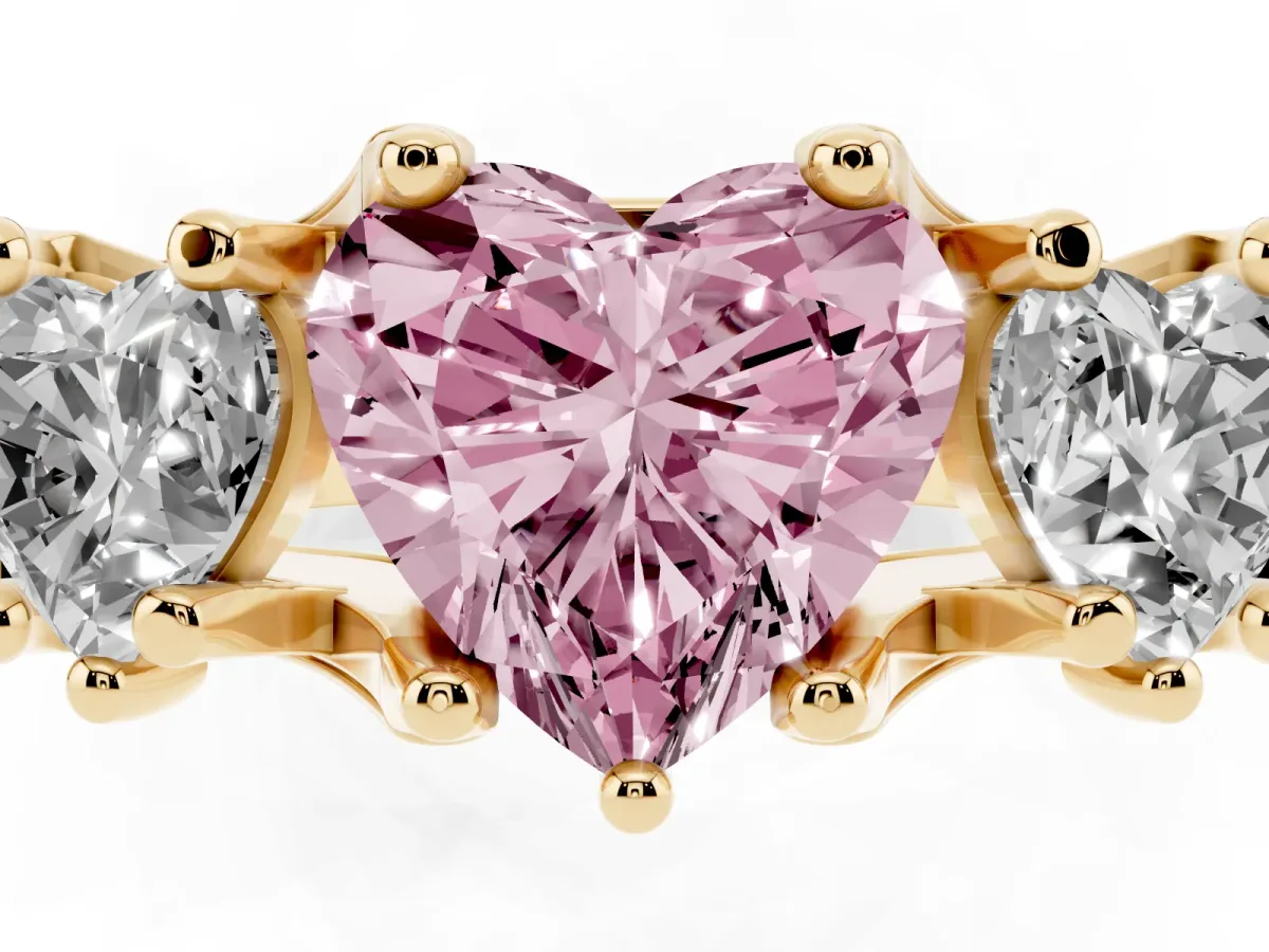 Fancy Pink Heart Cut Diamond Three-Stone Ring with Channel Set Band and Four-Prong Setting Yellow gold