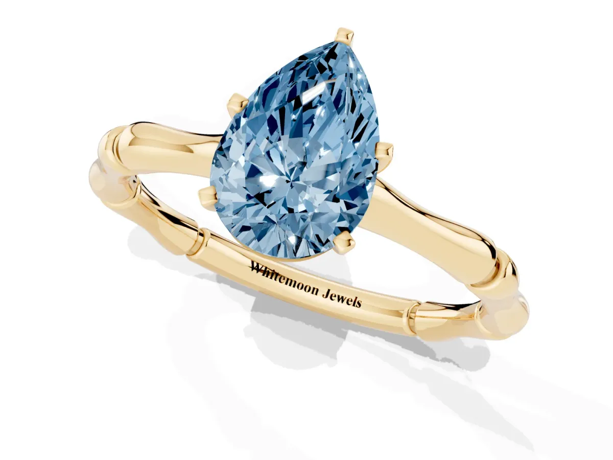 Fancy Blue Pear Cut Solitaire Diamond Ring with Bamboo Band and Four-Prong Setting Yellow gold