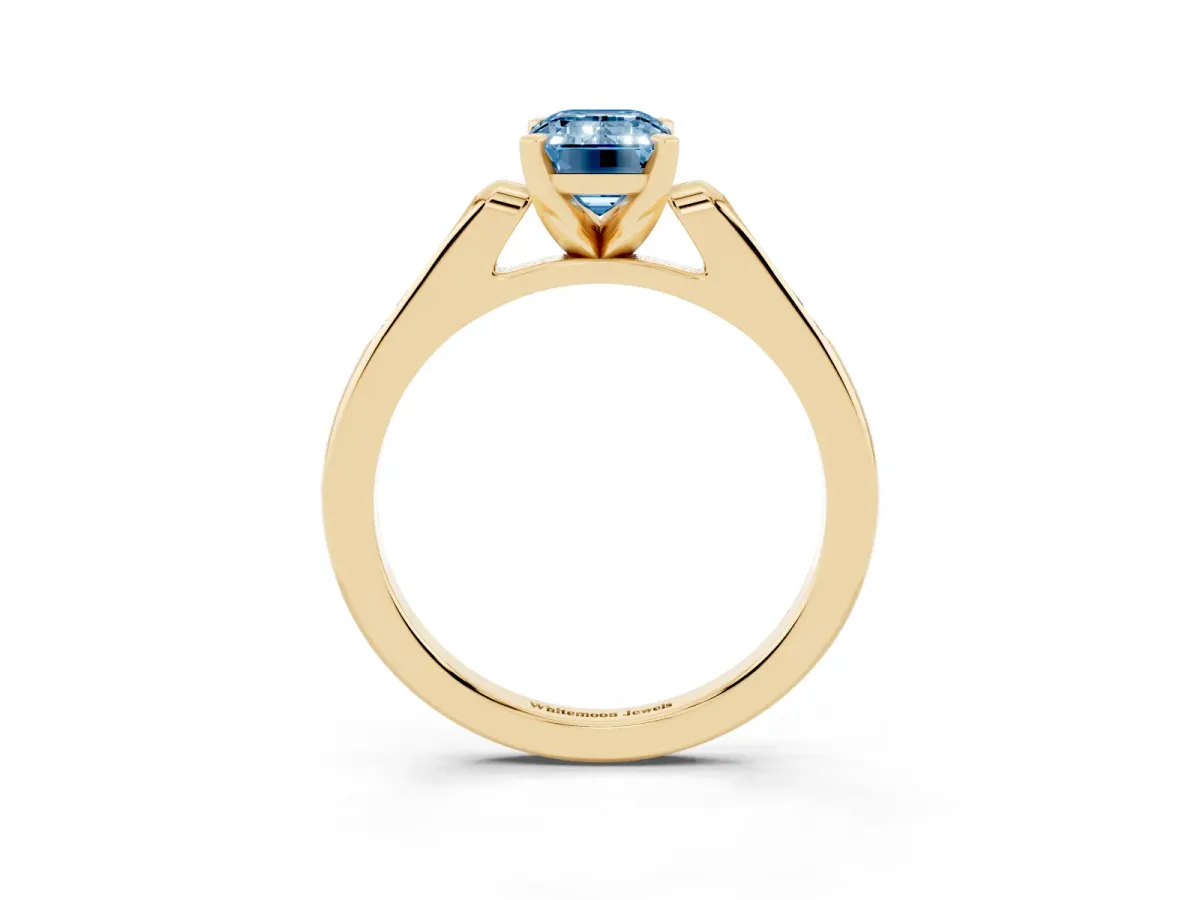 Fancy Blue Emerald Cut Diamond Solitaire Ring with Channel Set Round Band and Prong Setting Yellow gold