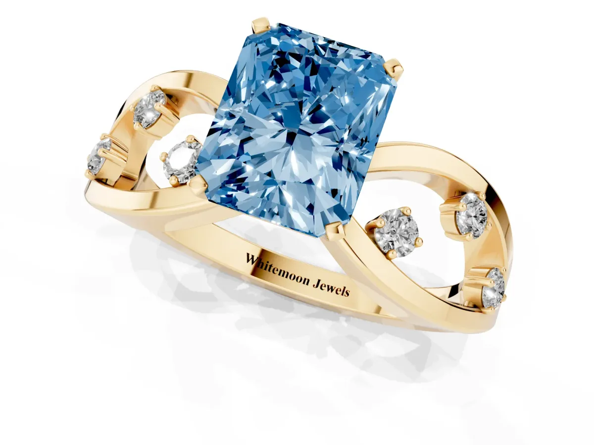 Fancy Blue Radiant Cut Cut Solitaire Diamond with Side Stones on Criss-Cross Band and Four-Prong Setting Yellow gold