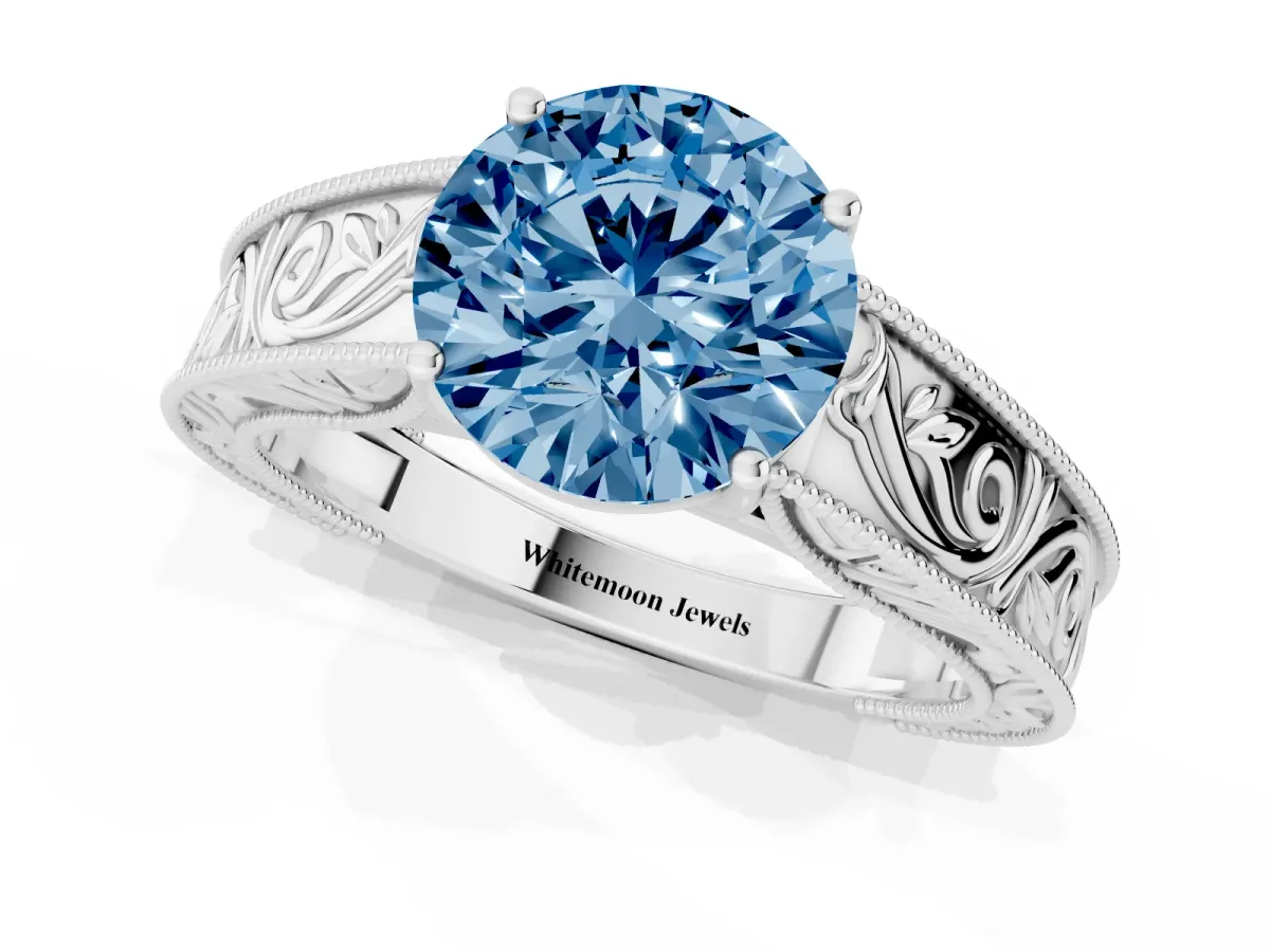 Fancy Blue Round Cut Diamond Solitaire Ring with Engraved Band and Four-Prong Setting White gold