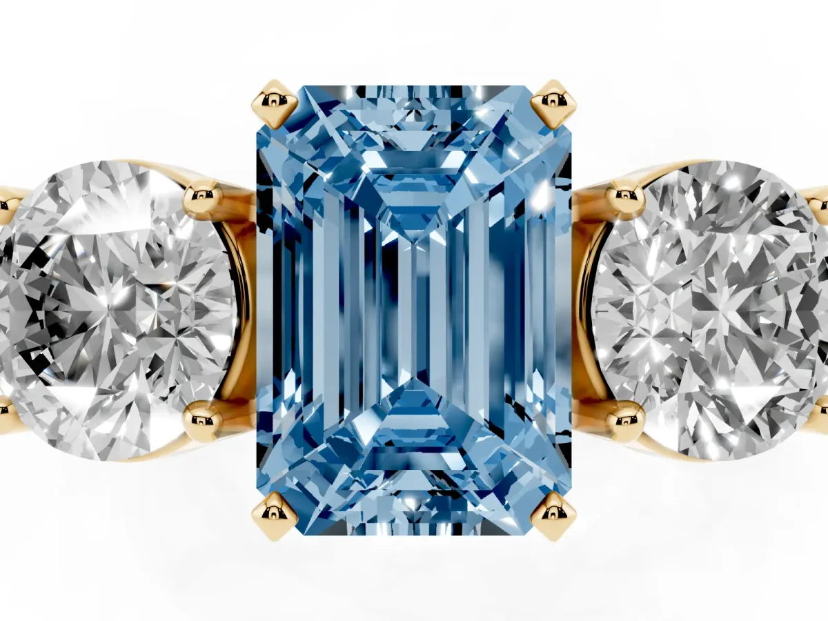 Fancy Blue Three-Stone Emerald Cut Diamond Ring with Round Side Stones, Classic Band, and Four-Prong Setting Yellow gold
